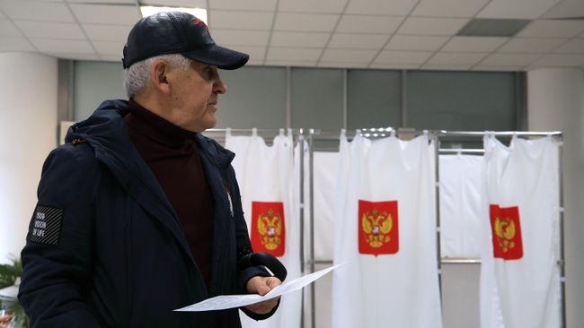 Мужчина голосует на выборах президента России