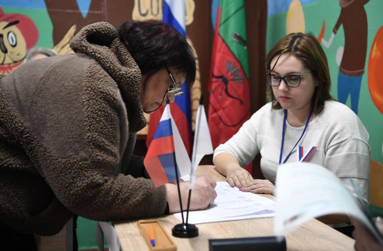 Женщина голосует на выборах президента России на избирательном участке в Константиновке Женщина голосует на выборах президента России на избирательном участке в Константиновке