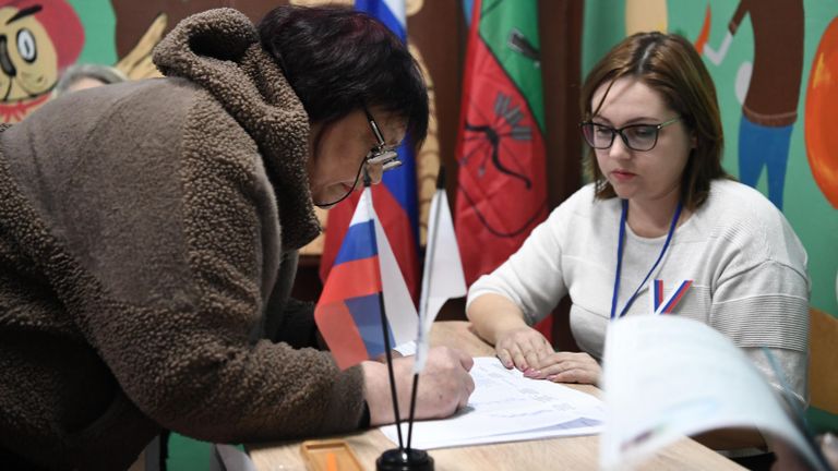 Женщина голосует на выборах президента России на избирательном участке в Константиновке