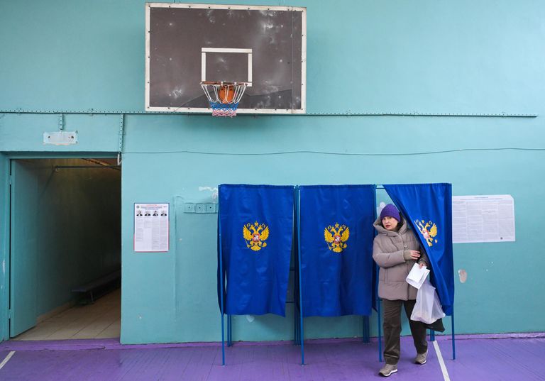 Женщина голосует на выборах президента России на избирательном участке в Новосибирске Женщина голосует на выборах президента России на избирательном участке в Новосибирске