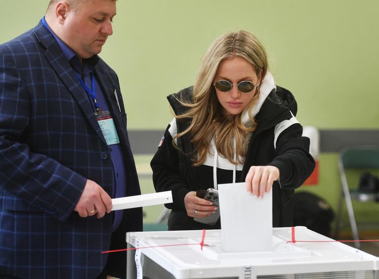Девушка голосует на выборах президента России на избирательном участке в Москве Девушка голосует на выборах президента России на избирательном участке в Москве