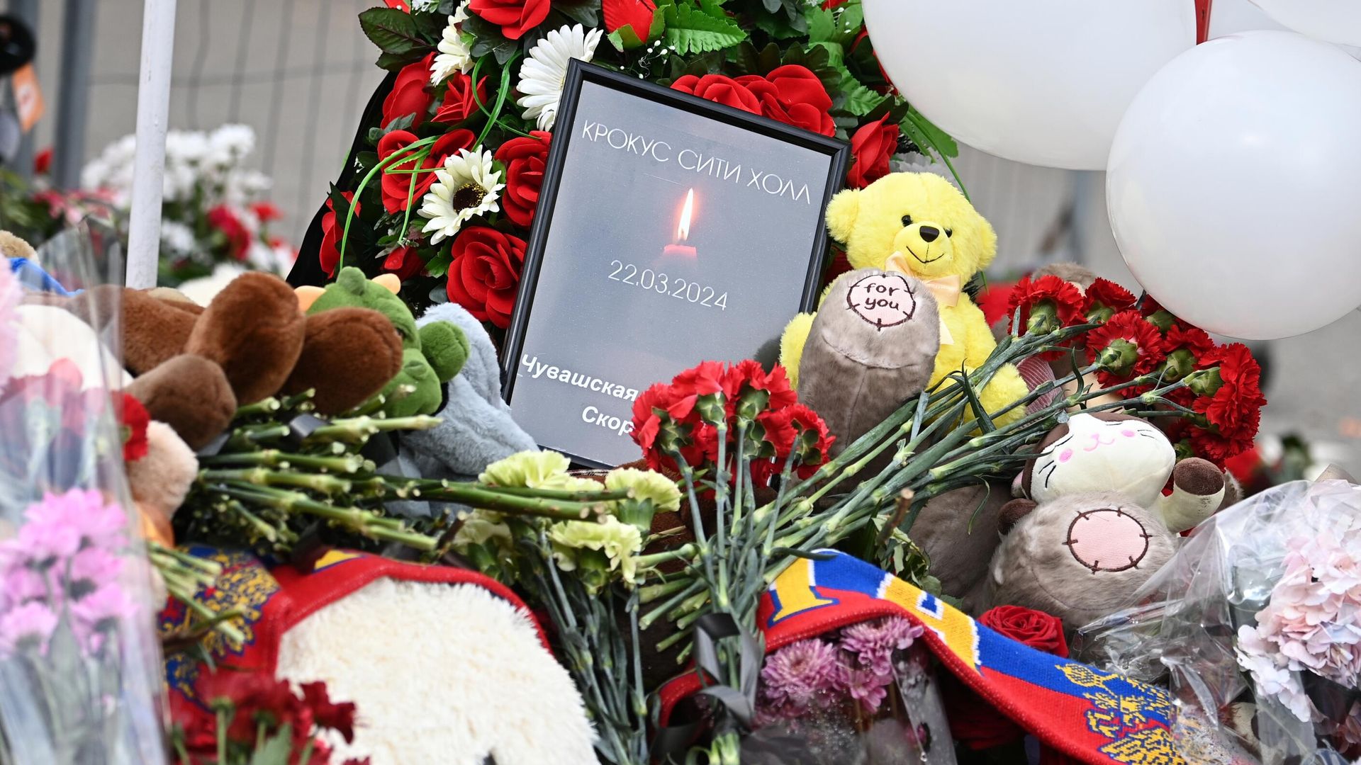 Цветы, игрушки и свечи на стихийном мемориале у здания концертного зала Крокус Сити Холл, где произошел теракт - РИА Новости, 1920, 25.03.2024