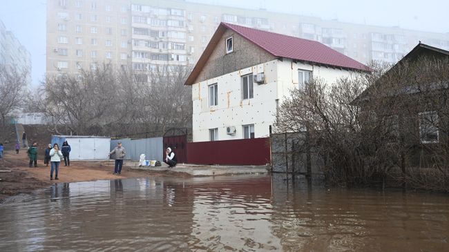 Местные жители на затопленной улице в микрорайоне Форштадт в Оренбурге