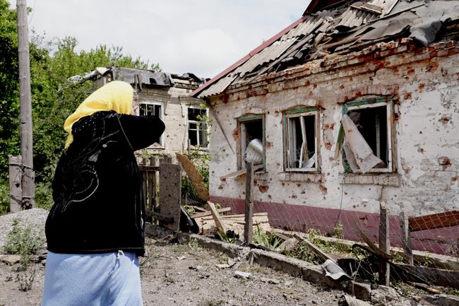 Пенсионерка плачет у разбитого дома своих погибших родственников Пенсионерка плачет у разбитого дома своих погибших родственников
