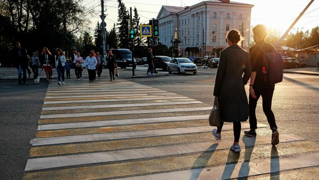 Прохожие переходят дорогу на закате в Архангельске Прохожие переходят дорогу на закате в Архангельске