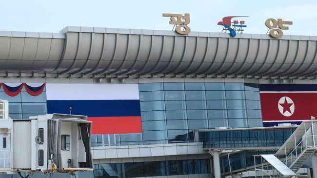 Аэропорт Пхеньяна, украшенный флагами РФ и КНДР и приветственными надписями