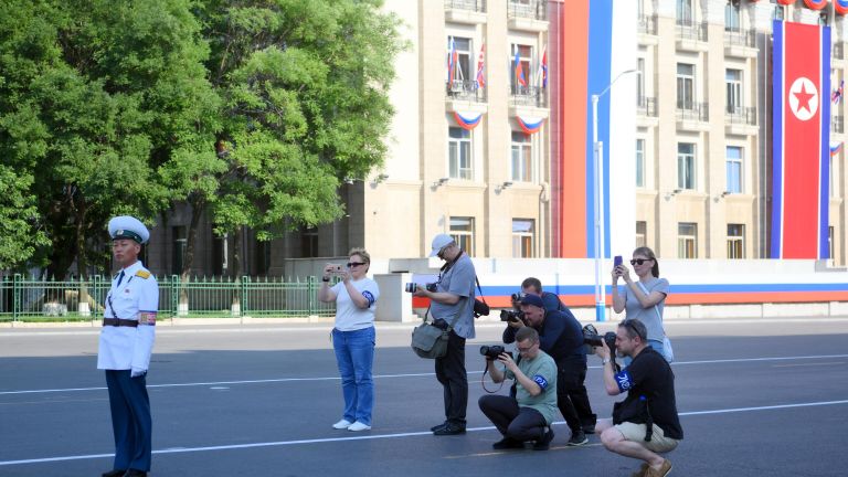 Журналисты занимаются фотосъемкой на улице в Пхеньяне перед визитом президента РФ Владимира Путина Журналисты занимаются фотосъемкой на улице в Пхеньяне перед визитом президента РФ Владимира Путина