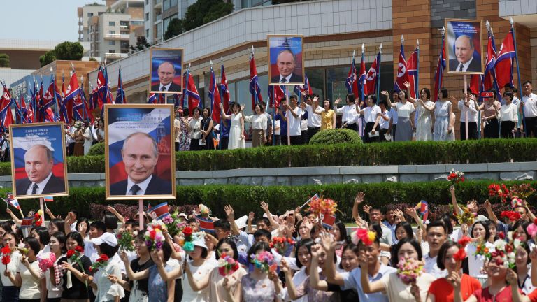 Люди приветствуют кортеж президента РФ Владимира Путина на улице в Пхеньяне Люди приветствуют кортеж президента РФ Владимира Путина на улице в Пхеньяне