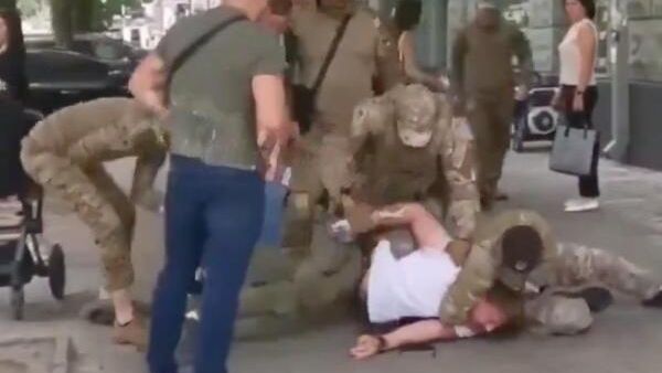 Cотрудники украинского военкомата отлавливают молодого отца на улице. Кадр видео - РИА Новости, 1920, 15.02.2025
