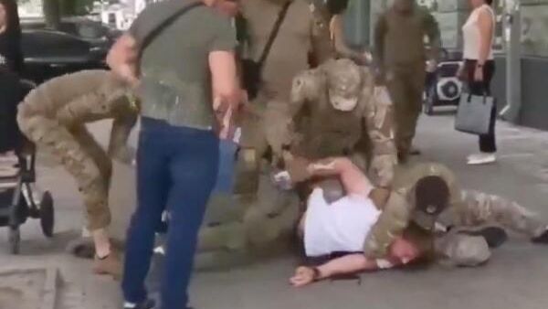 Cотрудники украинского военкомата отлавливают молодого отца на улице. Кадр видео - РИА Новости, 1920, 15.02.2025