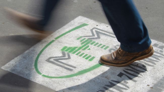 Реклама МММ на асфальте тротуара на одной из улиц Москвы