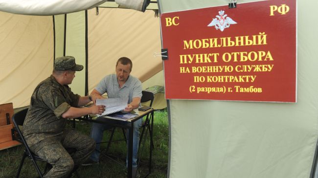 Инструктор беседует с мужчиной в мобильном пункте отбора на военную службу по контракту в селе Новое Тарбеево 