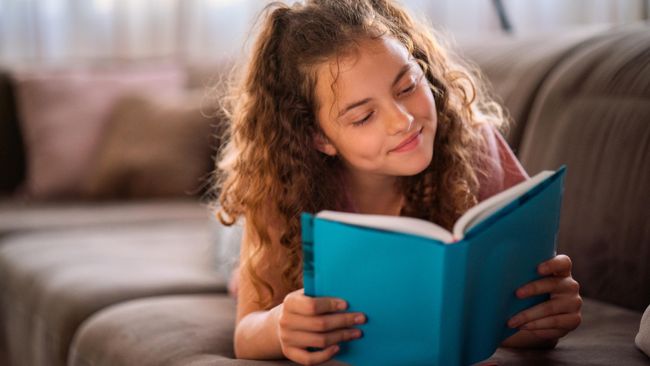 Подросток читает книгу дома