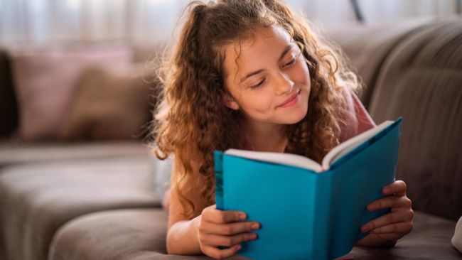 Подросток читает книгу дома