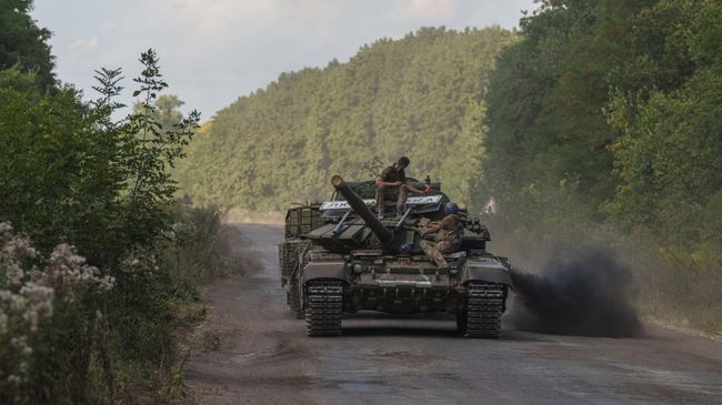 Украинские военнослужащие едут на танке с табличкой Любимовка недалеко от российско-украинской границы в Сумской области