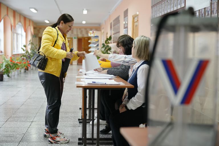 Женщина голосует на избирательном участке в Кемерово Женщина голосует на избирательном участке в Кемерово