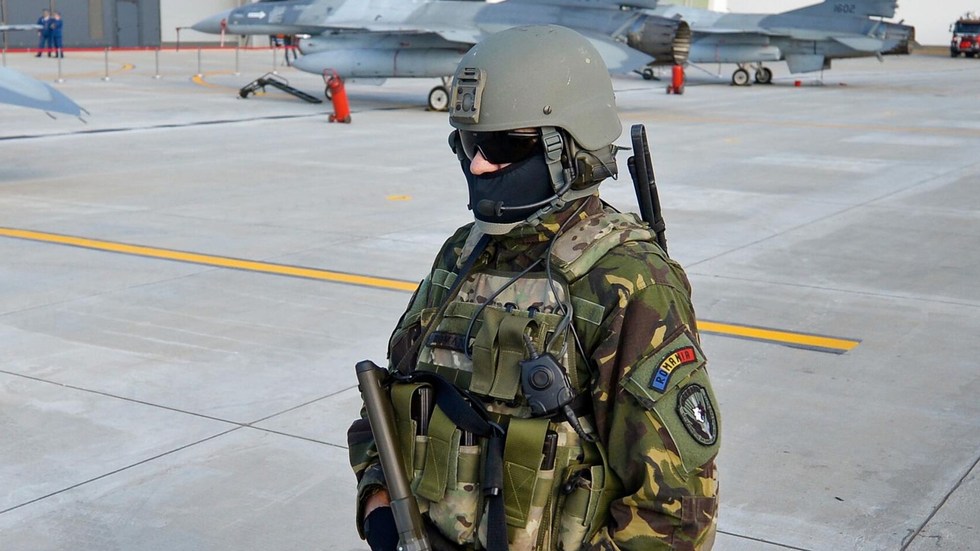 Румынский военный охраняет истребители F16 румынских ВВС на взлетно-посадочной полосе авиабазы в Борче Румынский военный охраняет истребители F16 румынских ВВС на взлетно-посадочной полосе авиабазы в Борче - РИА Новости, 1920, 31.12.2025