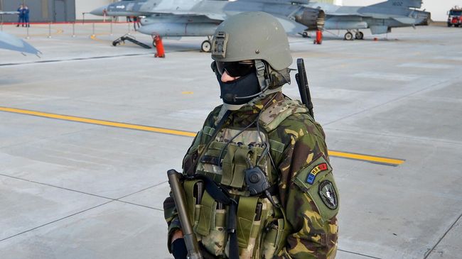 Румынский военный охраняет истребители F16 румынских ВВС на взлетно-посадочной полосе авиабазы ​в Борче