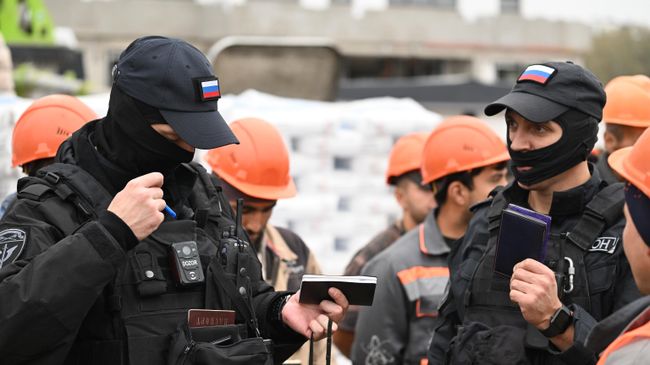 Проверка документов иностранных рабочих в ходе рейда по выявлению нелегальных мигрантов в Москве