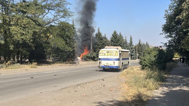 Автобус проезжает мимо горящего автомобиля Автобус проезжает мимо горящего автомобиля