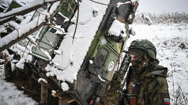 Военнослужащий батальонной тактической группы Каштана спецназа Ахмат возле подбитого бронеавтомобиля иностранного производства в Курской области