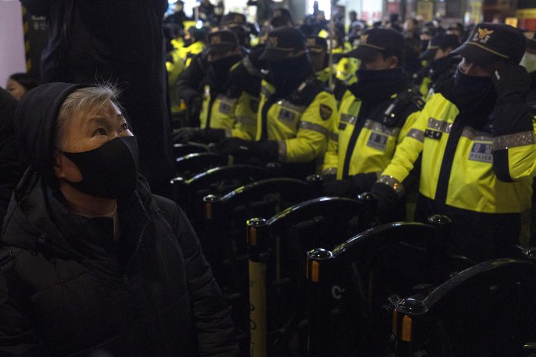Ряды полицейских блокируют шествие протеста к президентскому офису в Сеуле Ряды полицейских блокируют шествие протеста к президентскому офису в Сеуле
