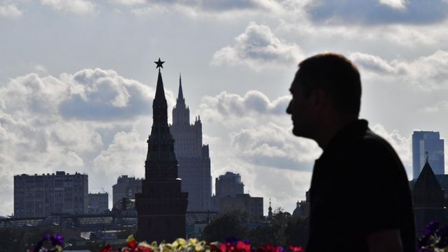 Мужчина идет по Большому Москворецкому мосту в Москве