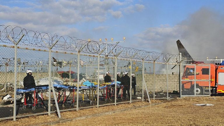 Спасатели возле обломков пассажирского самолета в международном аэропорту Муан, Южная Корея Спасатели возле обломков пассажирского самолета в международном аэропорту Муан, Южная Корея