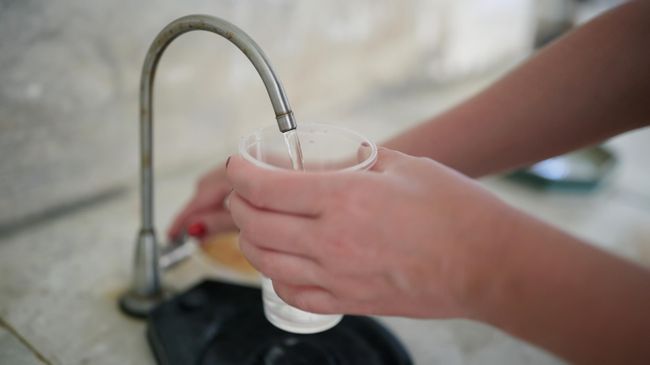 Девушка наливает питьевую воду Девушка наливает питьевую воду