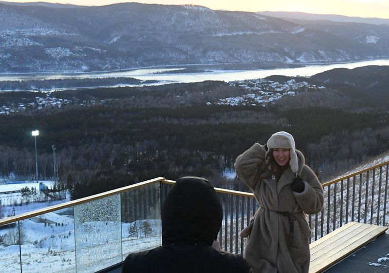 Люди во время заката на смотровой площадке Николаевской сопки - самой высокой географической точки в черте города Красноярска