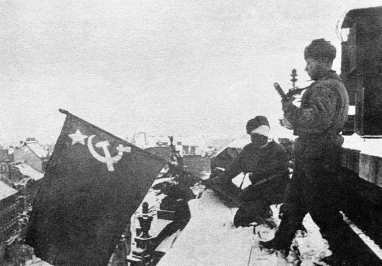 Старший сержант Евгений Костерев и младший сержант Александр Пертяков из 1405-го зенитного артиллерийского полка 38-й зенитно-артиллерийской Черкасской Краснознаменной дивизии Резерва Главного Командования устанавливают советский флаг над Будапештом Старший сержант Евгений Костерев и младший сержант Александр Пертяков из 1405-го зенитного артиллерийского полка 38-й зенитно-артиллерийской Черкасской Краснознаменной дивизии Резерва Главного Командования устанавливают советский флаг над Будапештом