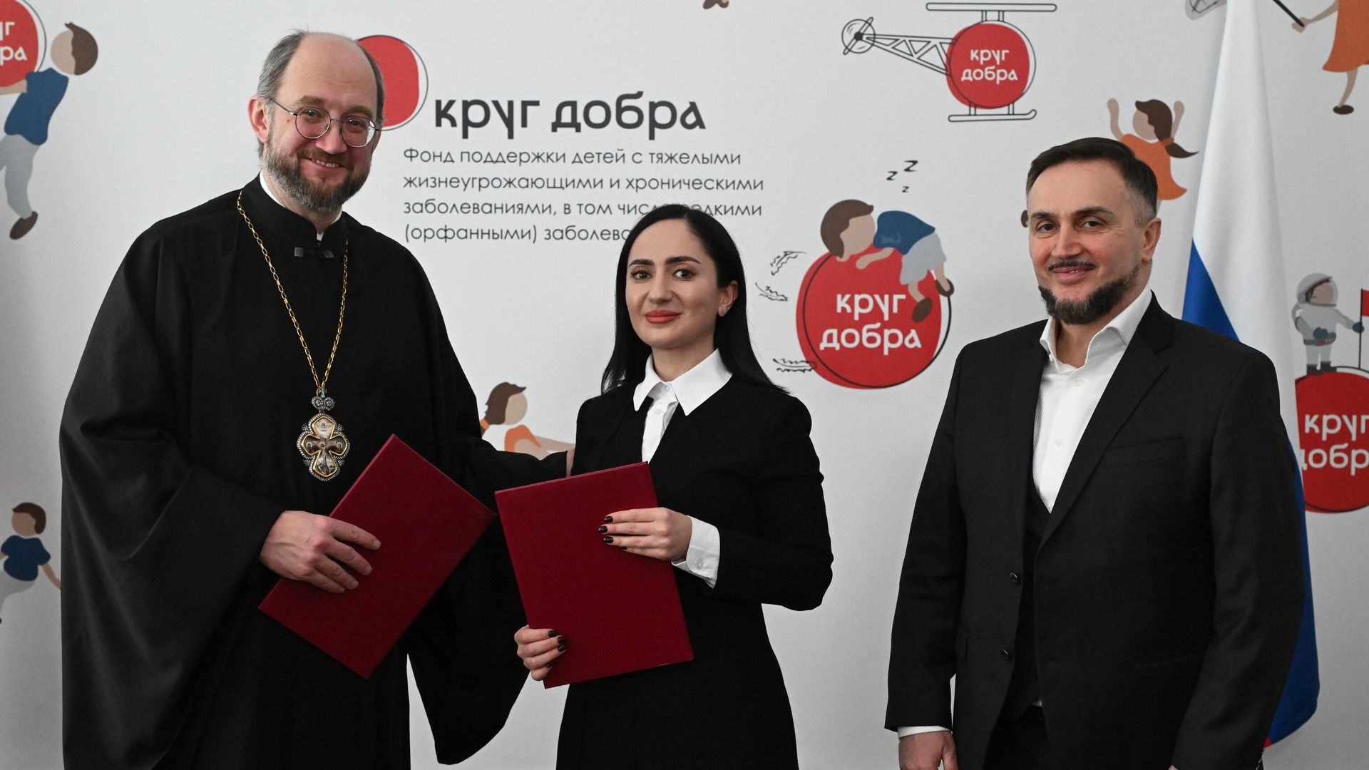 Председатель правления Фонда Круг добра, председатель Комиссии по вопросам социального партнерства, попечения и развитию инклюзивных практик Общественной Палаты РФ протоиерей Александр Ткаченко, директор культурно-благотворительного фонда Ашана Мактина Джинджолия и учредитель фонда Ашана Беслан Шакая на церемонии подписания соглашения о сотрудничестве в Москве - РИА Новости, 1920, 26.02.2025