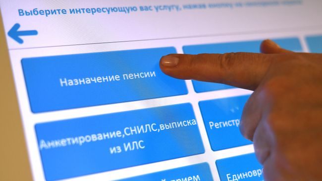 Человек выбирает услугу в терминале в ПФР