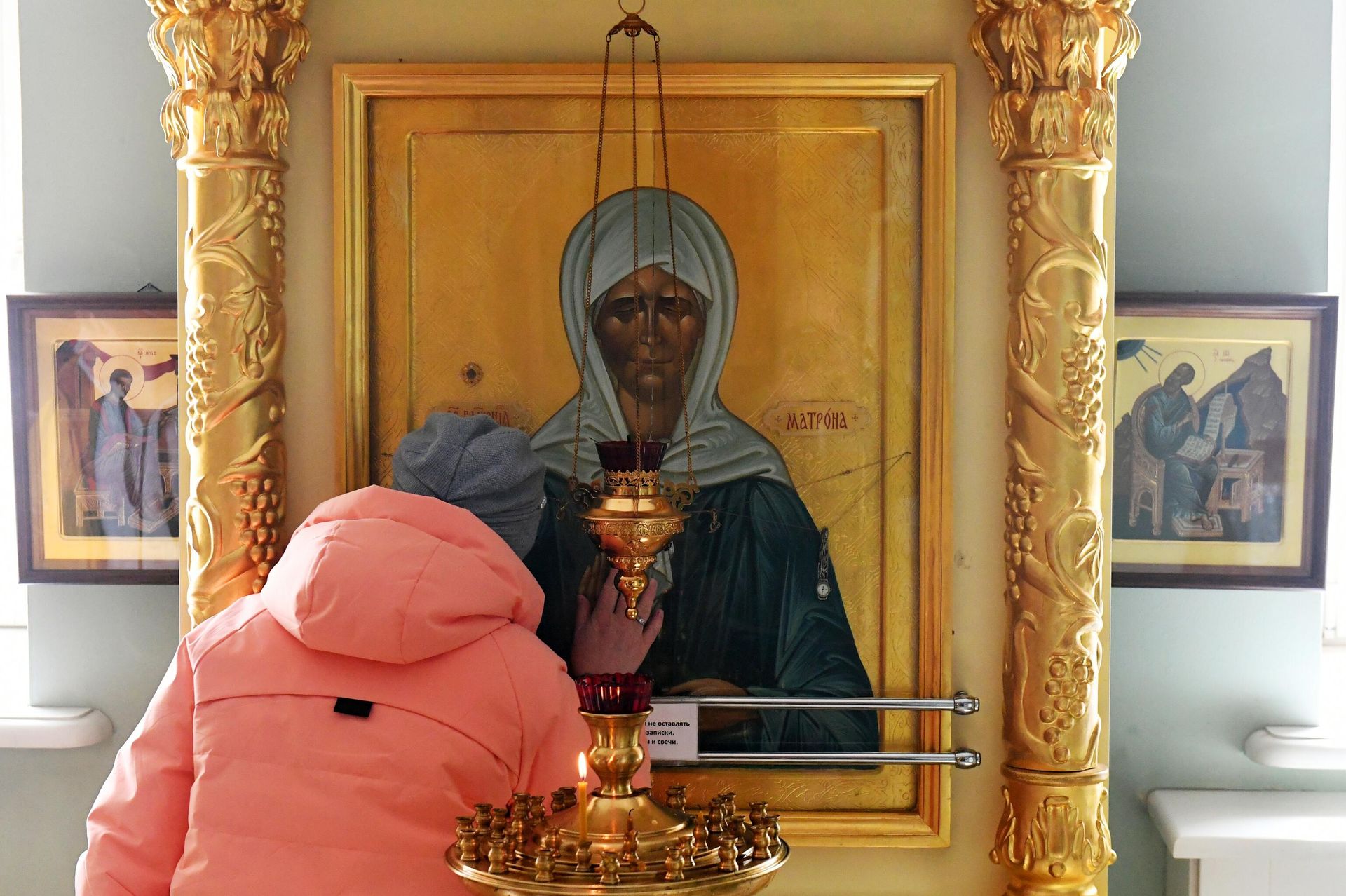 Верующая молится у иконы святой Матроны Московской Верующая молится у иконы святой Матроны Московской - РИА Новости, 1920, 15.04.2026