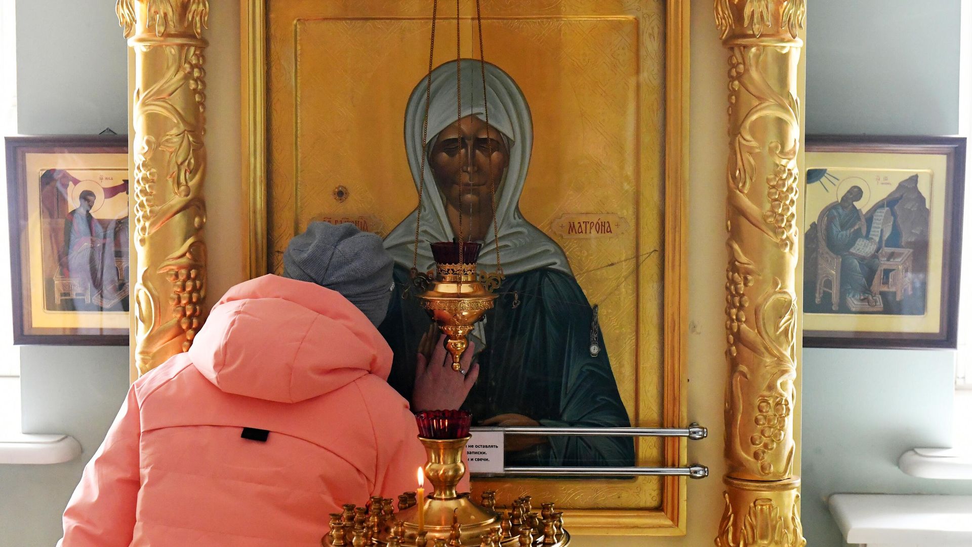 Верующая молится у иконы святой Матроны Московской Верующая молится у иконы святой Матроны Московской - РИА Новости, 1920, 17.05.2026