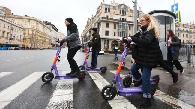 Люди на самокатах пересекают Театральный проезд в Москве Люди на самокатах пересекают Театральный проезд в Москве