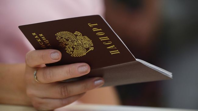 Российский паспорт в руке девушки Российский паспорт в руке девушки