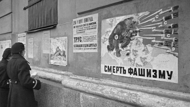 Военнослужащие Балтийского флота у плакатов Окна ТАСС на стене здания в блокадном Ленинграде