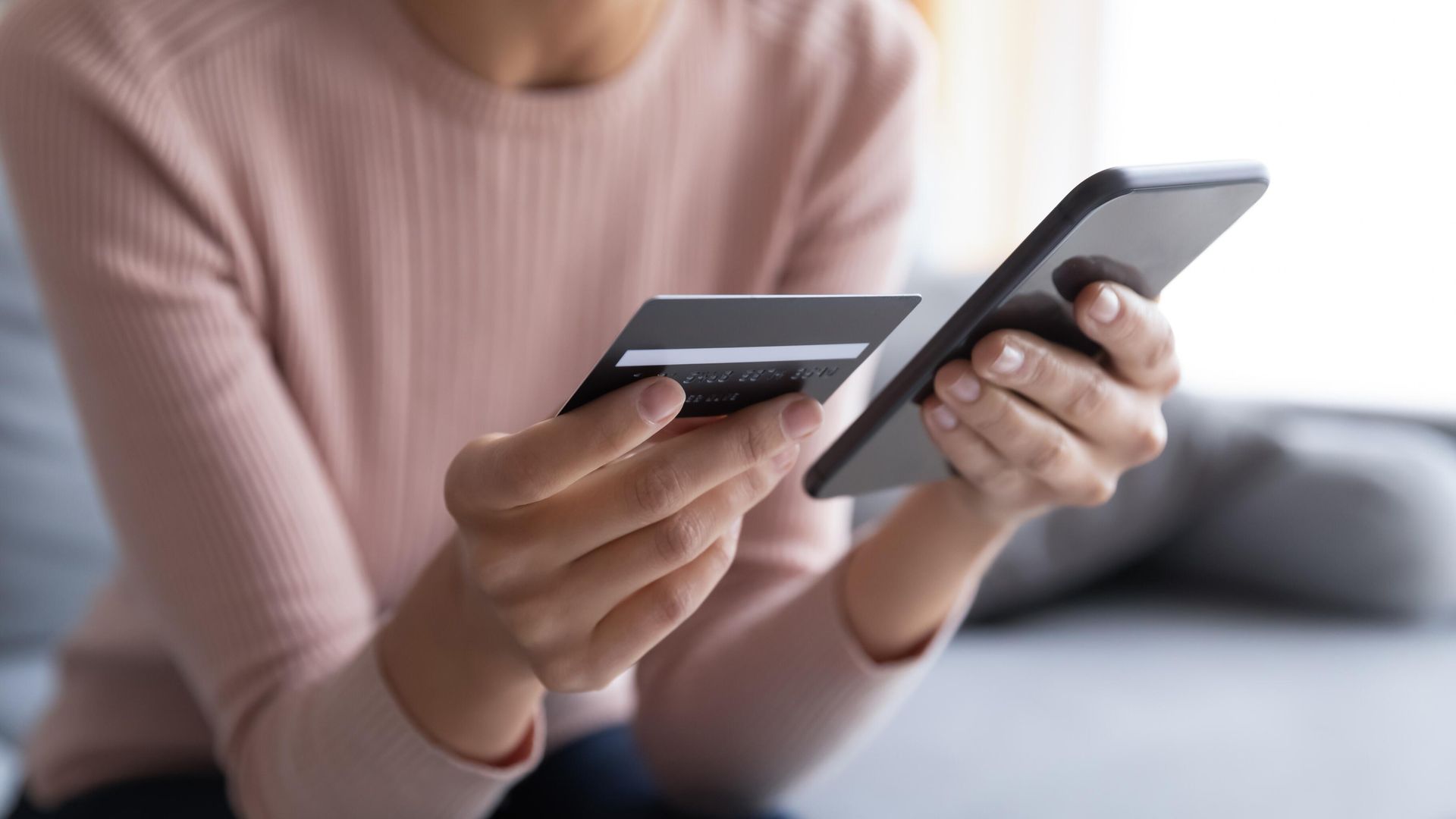 Девушка держит в руках кредитную карту и смартфон Девушка держит в руках кредитную карту и смартфон - РИА Новости, 1920, 26.03.2025