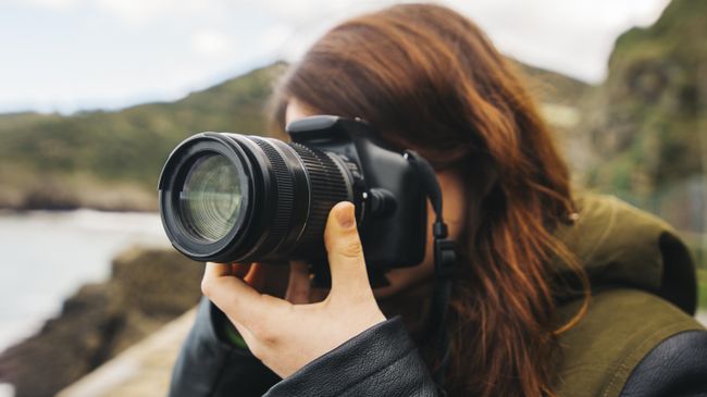 Девушка использует фотоаппарат