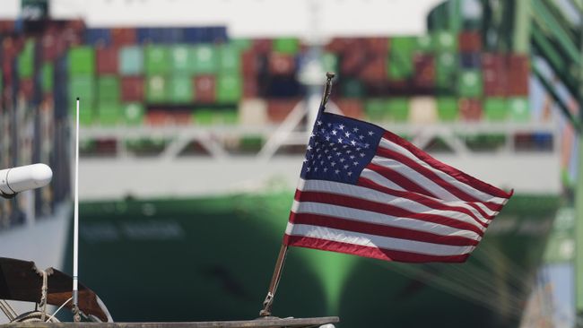 Флаг США на фоне контейнеровоза в порту Лос-Анджелеса, США