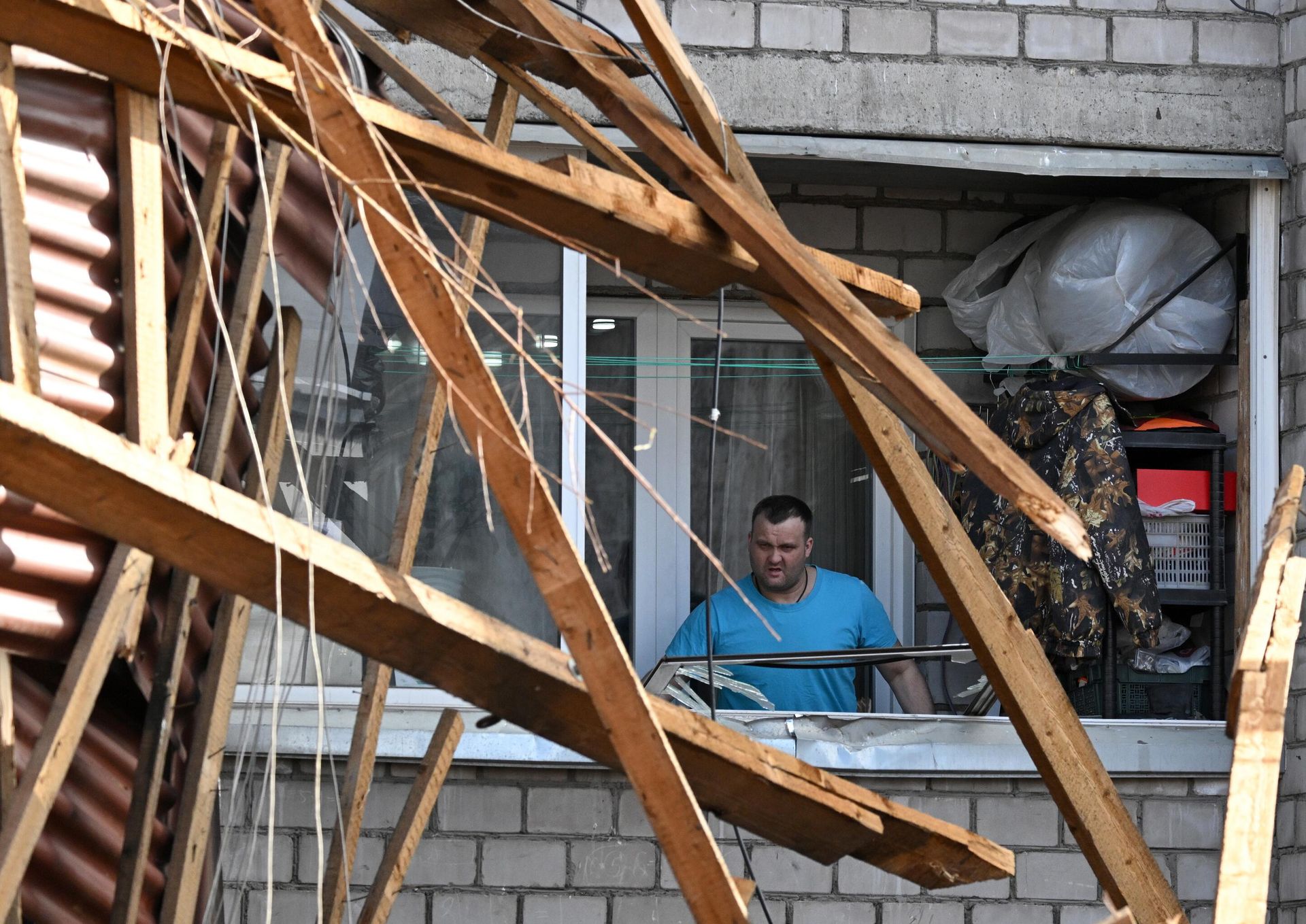 Мужчина осматривает разрушения в лоджии своей квартиры жилого пятиэтажного дома, повреждённой в результате падения крыши во время ураганного ветра, на Северо-Енисейской улице в Красноярске - РИА Новости, 1920, 05.04.2025