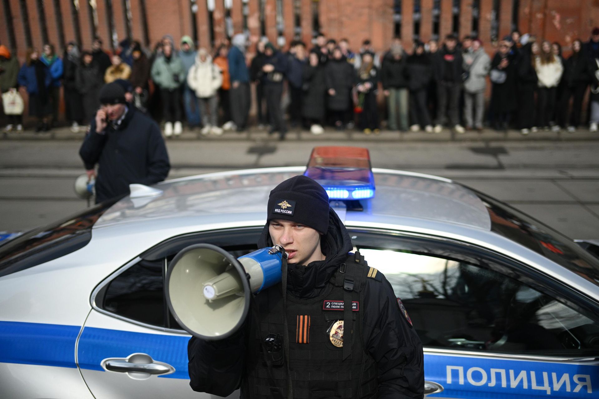 Сотрудник полиции во время церемонии прощания с рэпером Пашей Техником (настоящее имя – Павел Ивлев) возле храма Петра и Павла в Лефортово в Москве Сотрудник полиции во время церемонии прощания с рэпером Пашей Техником (настоящее имя – Павел Ивлев) возле храма Петра и Павла в Лефортово в Москве - РИА Новости, 1920, 11.04.2025
