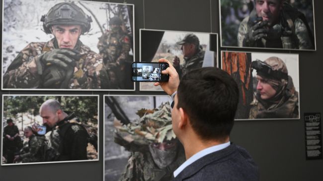 Посетитель на выставке Защитники Отечества с работами военных фотокорреспондентов РИА Новости из зоны специальной военной операции в Музее Победы