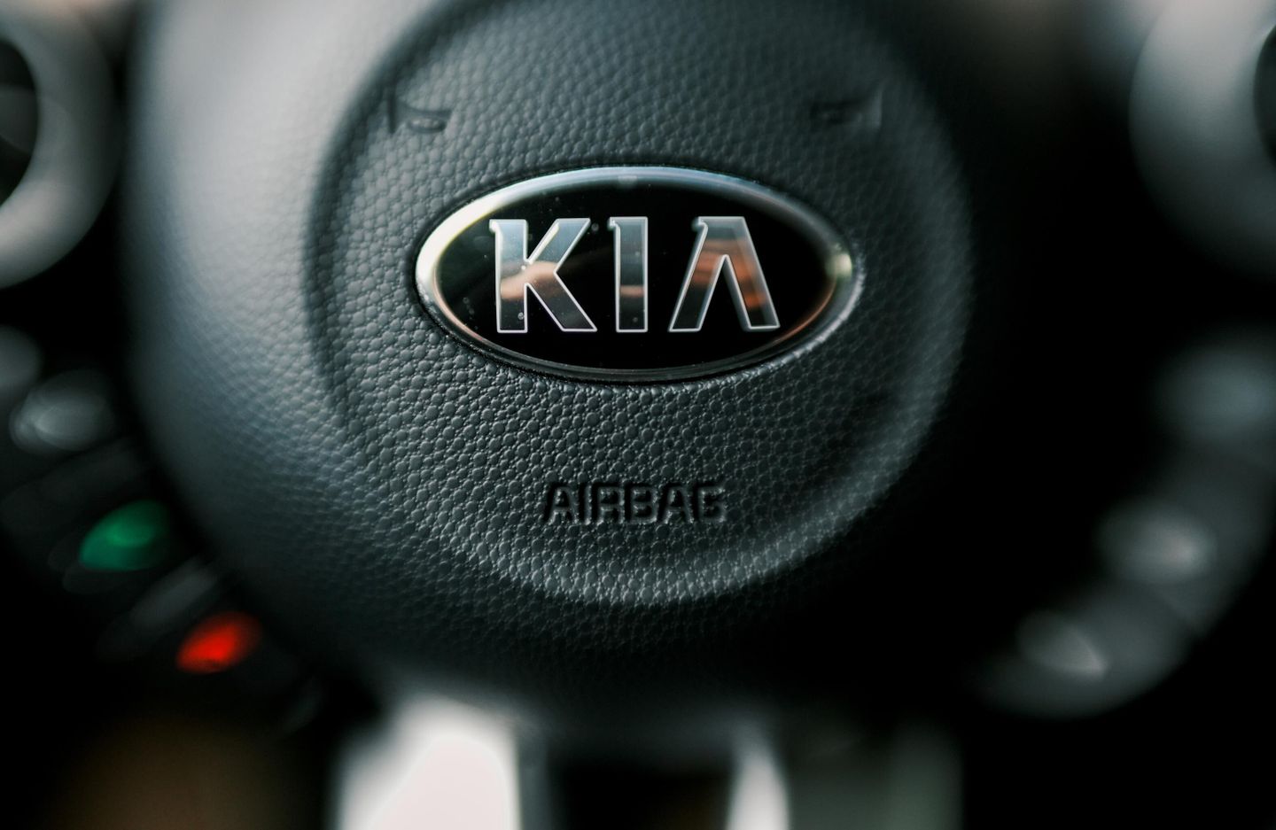 Логотип южнокорейской автомобилестроительной компании Kia на руле автомобиля Логотип южнокорейской автомобилестроительной компании Kia на руле автомобиля