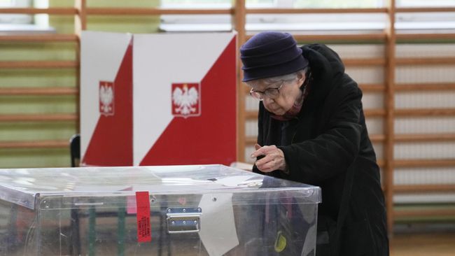 Женщина голосует в первом туре президентских выборов на избирательном участке в Варшаве, Польша