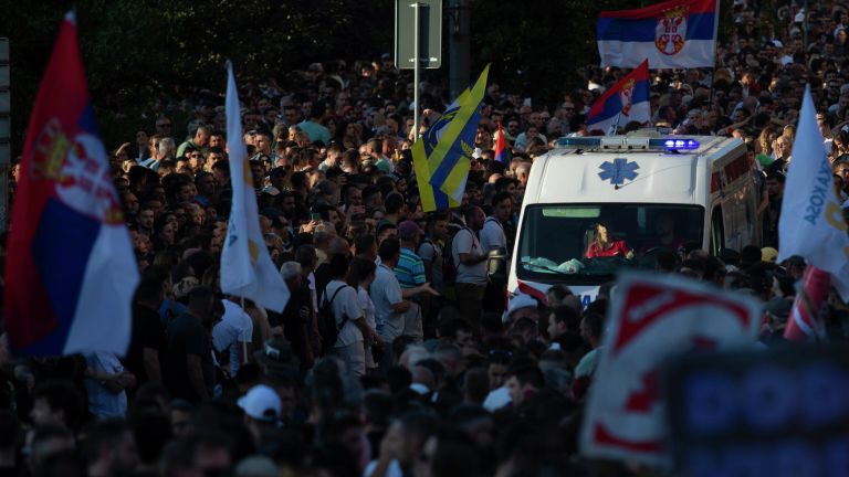Машина скорой помощи едет во время акции протеста в Белграде
