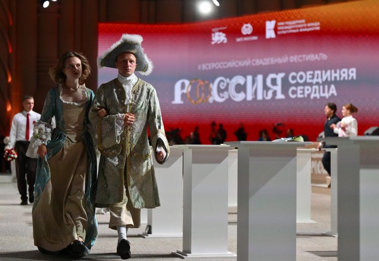 Участники Всероссийского свадебного фестиваля Россия. Соединяя сердца во время торжественной церемонии бракосочетания в Национальном центре Россия в Москве Участники Всероссийского свадебного фестиваля Россия. Соединяя сердца во время торжественной церемонии бракосочетания в Национальном центре Россия в Москве