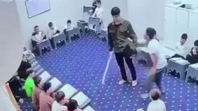 Кадр видео, на котором учитель школы в г. Гудермес наносит удары палкой двум несовершеннолетним ученикам
