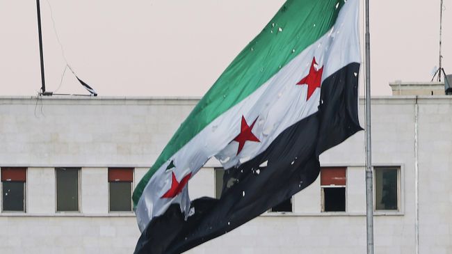 Сирийский флаг у здания Министерства обороны Сирии в Дамаске после израильского удара